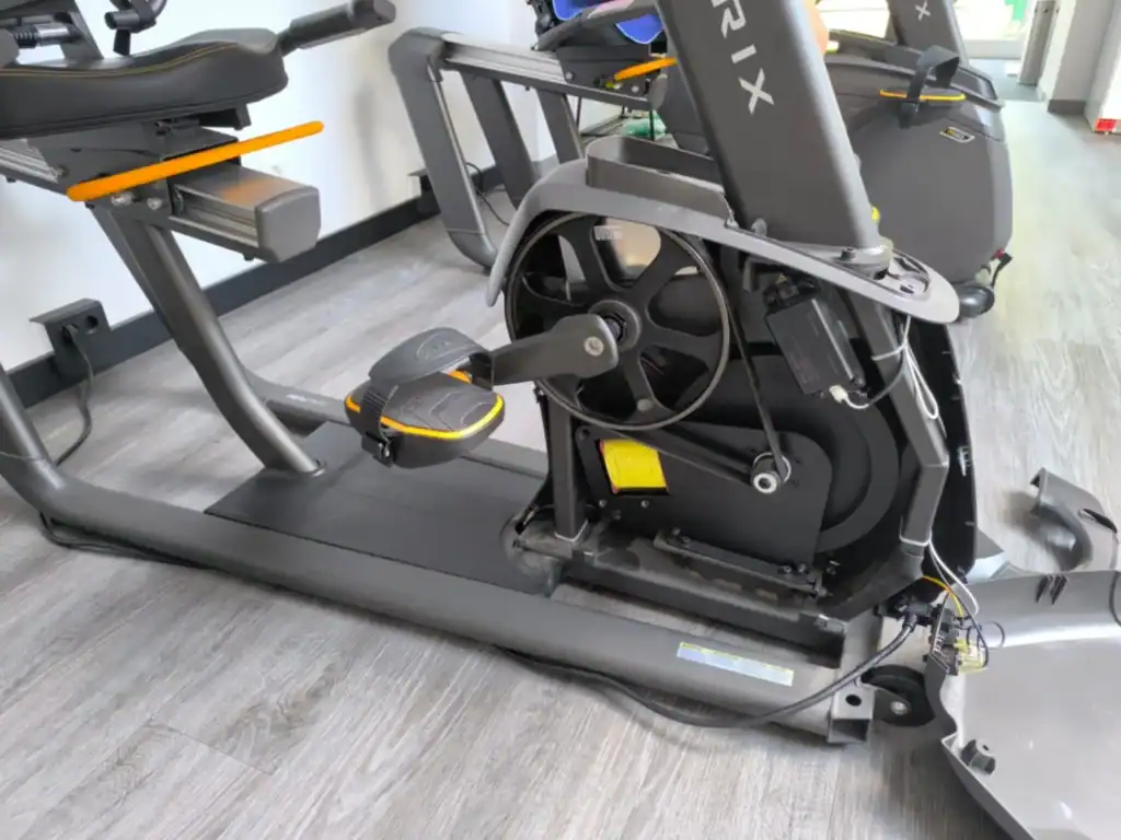 Reparatie van een professionele Matrix hometrainer door een monteur in de fitnessruimte