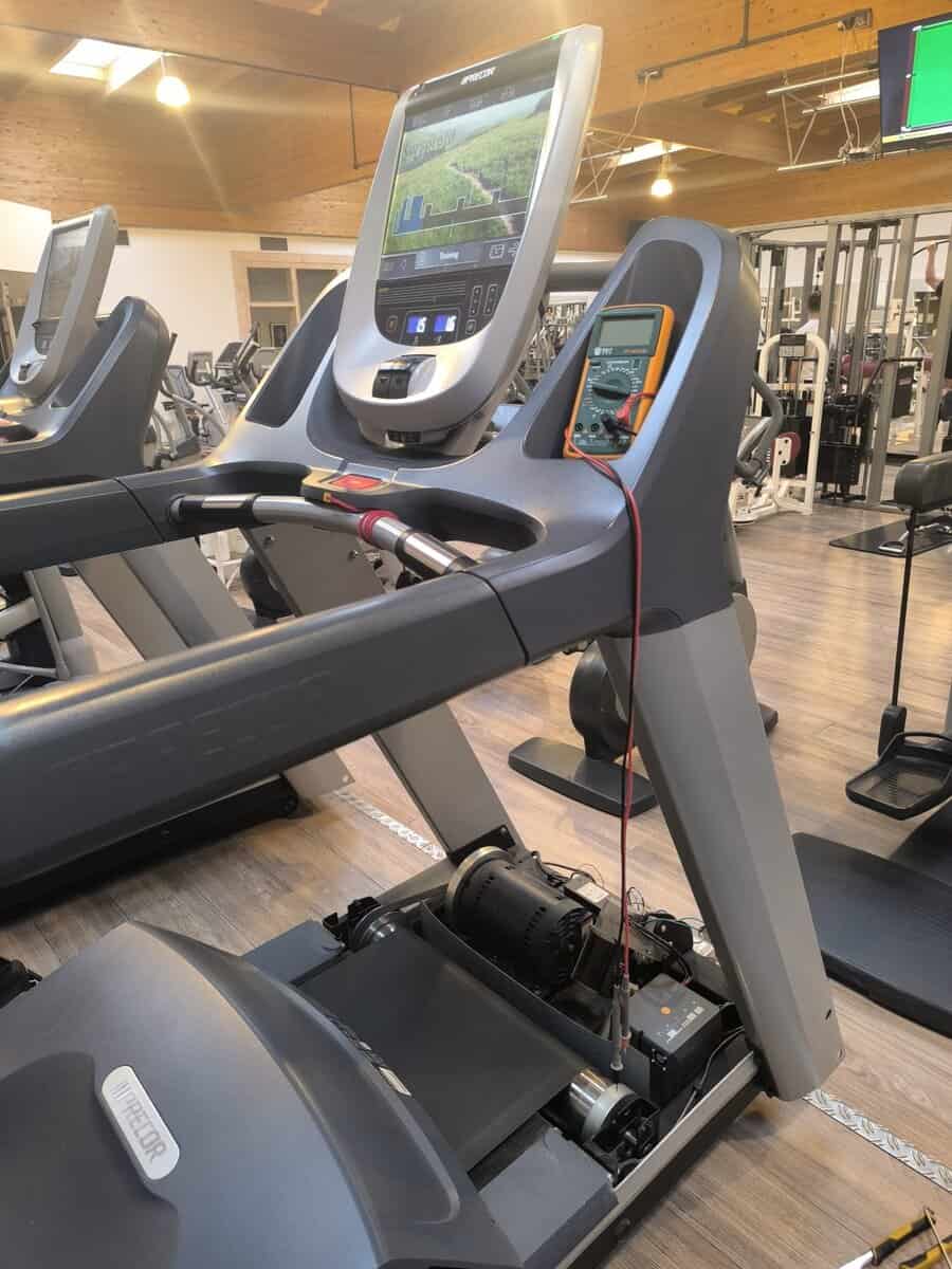 Technische diagnose van een Precor loopband met multimeter in een sportschool