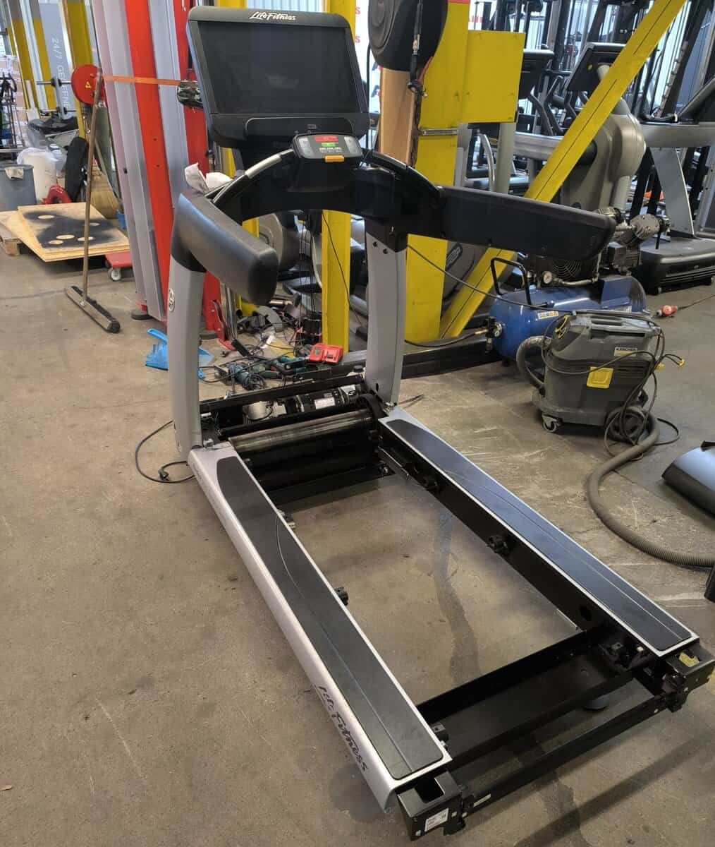 Life Fitness loopband gedemonteerd voor reparatie en volledige revisie in de werkplaats